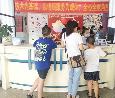 成都妈妈带着小男孩在四川省生殖健康研究中心附属生殖专科医院前台咨询包皮手术挂号情况